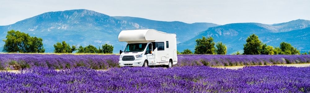Motorhome driving between fields of lavender in Provence, France