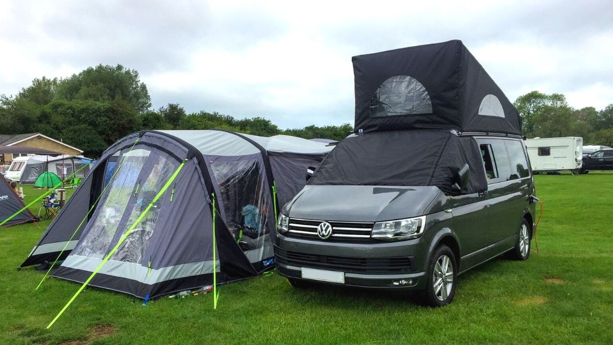 Campervan with drive-away awning on a grassy campsite