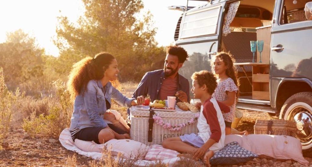 Family having a picnic next to their VW camper van